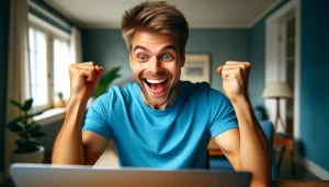 An excited man in his early twenties with short blonde hair, wearing a bright blue t-shirt. He is sitting in front of a laptop and Unsubscribing from Apps and happy while saving personal data and also extra bills